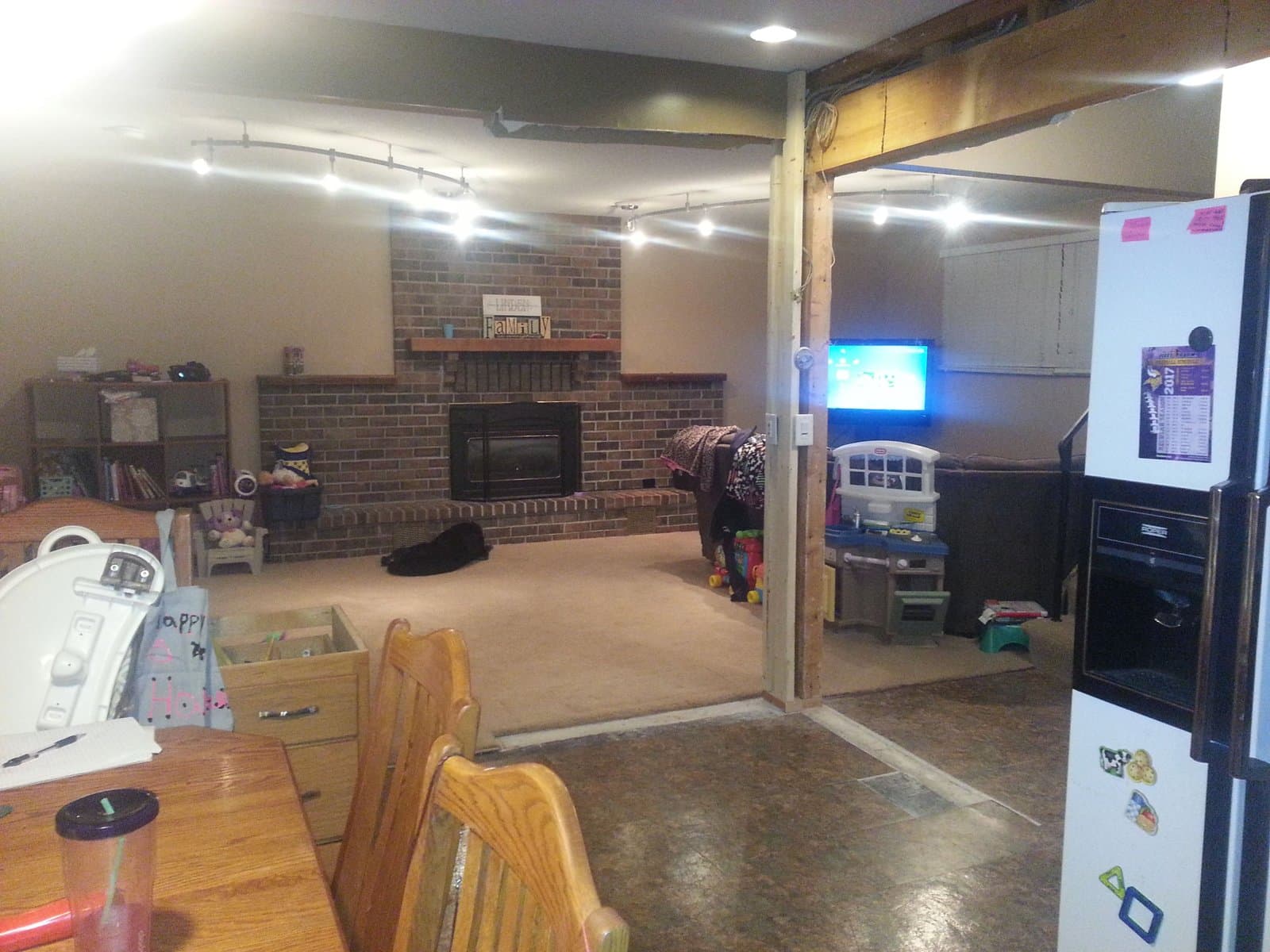 The bare brick fireplace wall and the post left where the wall was