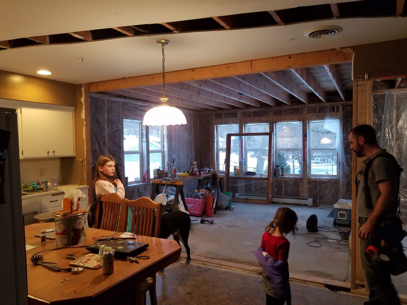 Living in it while building it: dinner in the old dining room, the new one framed behind, December 2018