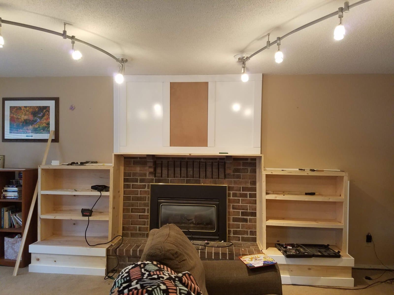 Built-in shelving going up on both sides of the fireplace, May 2018