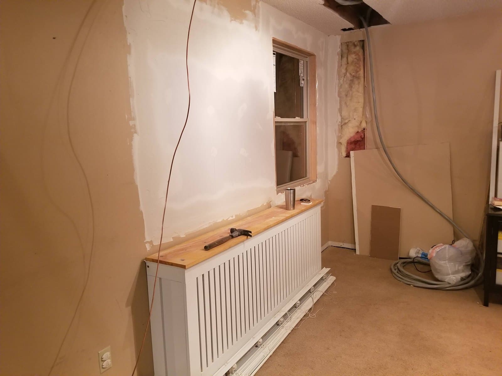 The old window position walled in and a smaller window set in its place; below it, the enclosure I built for the radiant heat