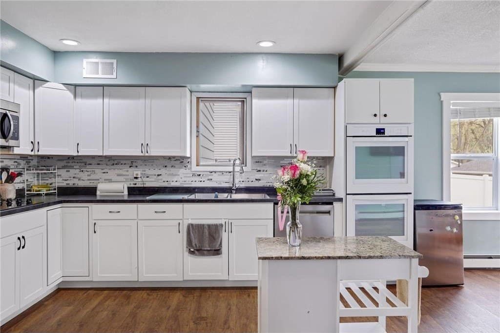 The kitchen, white cabinets, the double wall oven