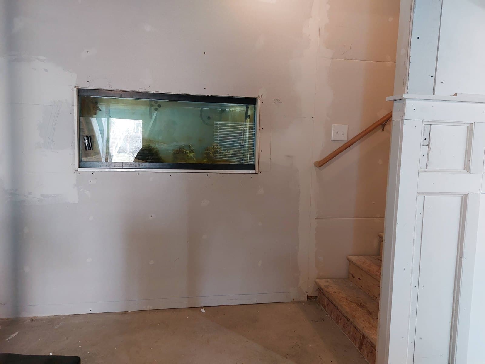 The tank framed into the wall from the room side, drywall up, April 2024