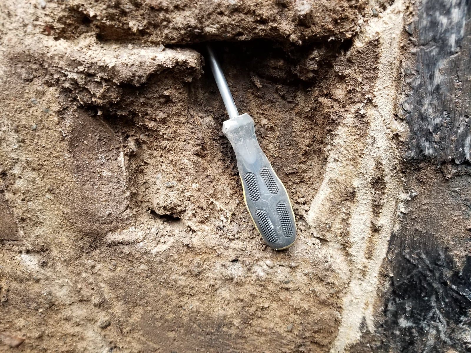 A screwdriver pushed into the block by hand