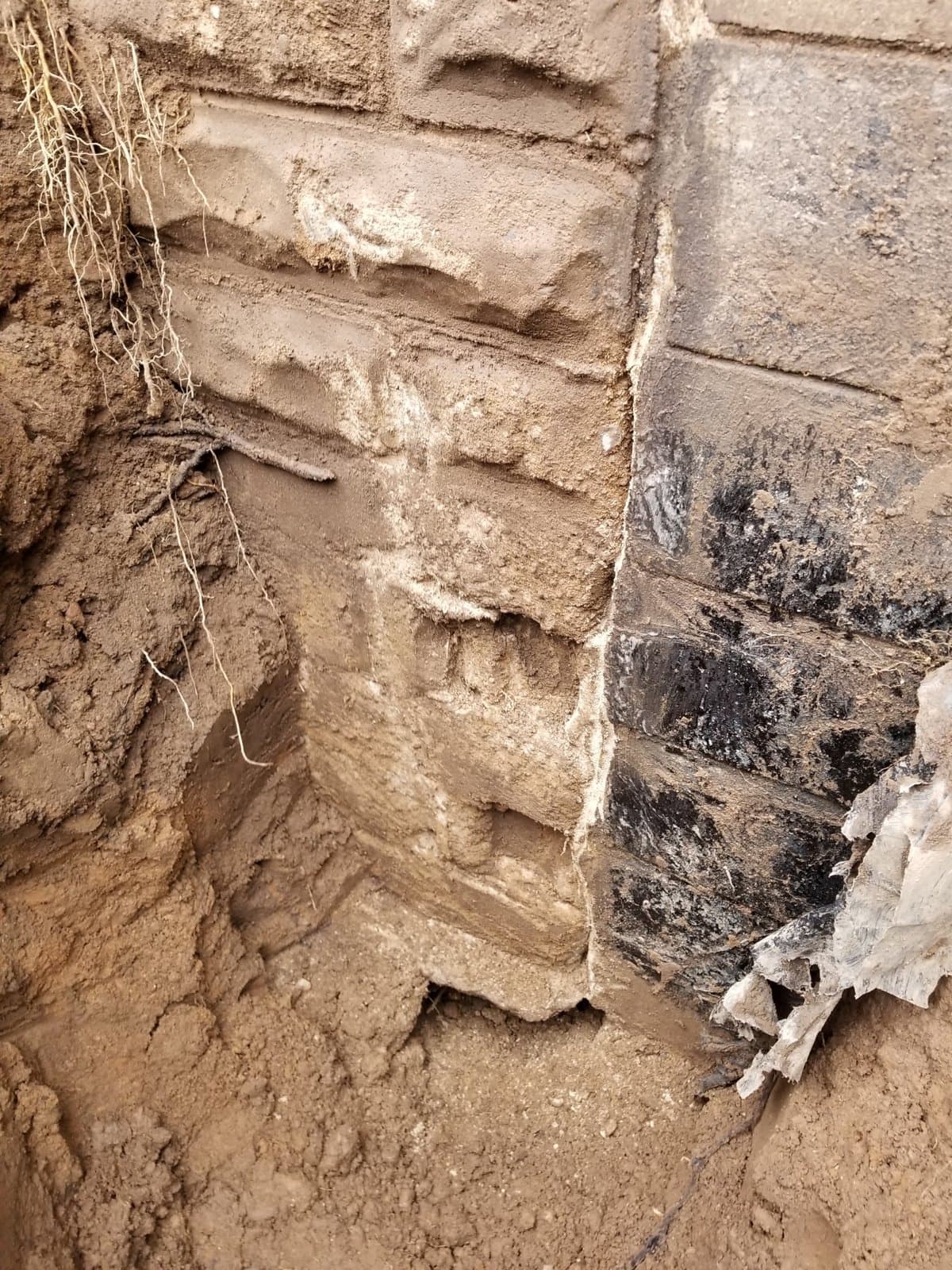 The same wall from outside, after digging, coated in old tar