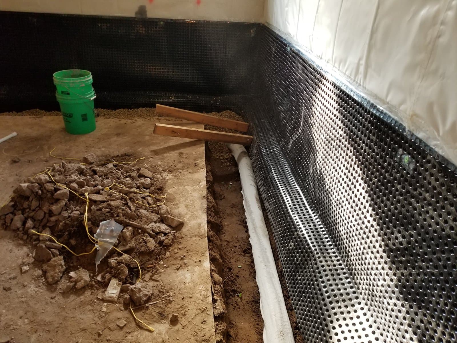 Drain tile laid in the trench around the basement perimeter, dimple membrane up the wall, October 2018